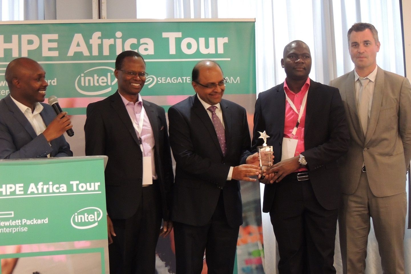 Computech Limited’s Dipak Galaiya and David Okwach receive the Overall HPE Partner of the Year Award, while HPE East Africa MD James Munene looks on.
